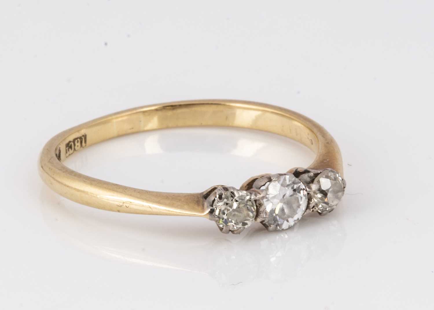 An 18ct gold and platinum diamond three stone dress ring,