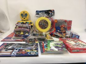 Box of Transformer toys and associated merchandise..mainly unopened in the original packaging…No