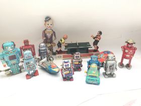 A collecton of loose vintage style tin toys icluding a wind up table tennis game. Robots and a drumm