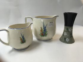 Two new hall Staffordshire jugs decorated with flowers and foliage and a small vase also decorated