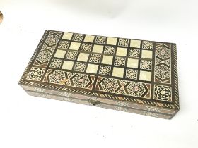 A mother of pearl inlaid games board and accessori