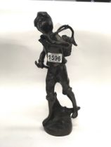 A bronze figure of a farmworker carrying a basket