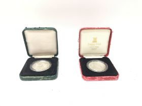 Two cased sterling silver coins. (A)