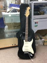 A Fender Squier Stratocaster electric guitar with gigging bag and spare strings. Shipping category