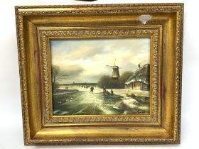 A gilt framed oil on board of a Dutch winter scene