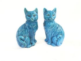 A pair of Modelled Chinese figure of a seated cat.