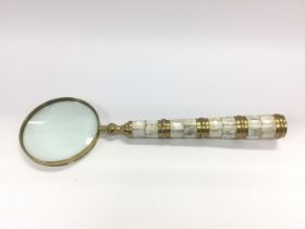 A large brass and mother of pearl handled magnifyi