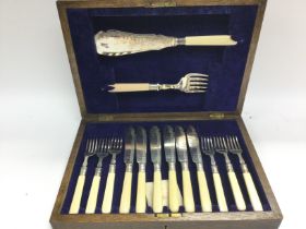 A silver plate fish cutlery set in wooden case. No