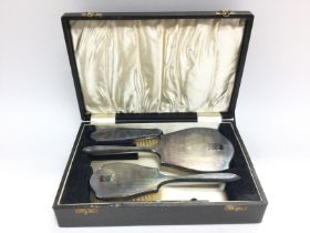 A silver plate case brush set.