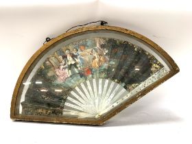 An antique decorative French hand painted mother of pearl fan set in a gilt case. (Some damage).