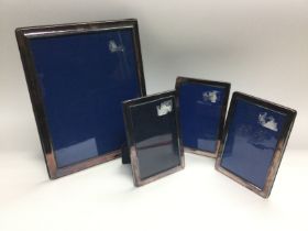 Four silver plated photo frames comprising one lar