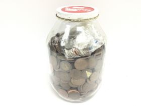 A collection of coinage including a large jar of p