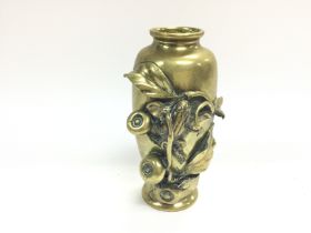 A Japanese late 19th Century brass vase with raise