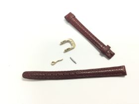 A dark red leather watch strap with buckle fastene