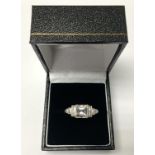 WITHDRAWN - A platinum ring set with baguette diamond shoulders with Ascher cut centre stone,