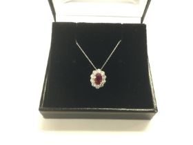 A platinum Burmese ruby and diamond halo pendant o