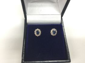 A pair of 18ct white gold oval cut sapphire and ro