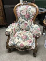 A Victorian walnut arm chair with carved scroll su