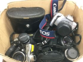 A box of cameras and lenses including Canon and Pe