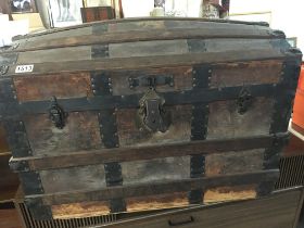 An Antique dome top trunk with wood and metal bind