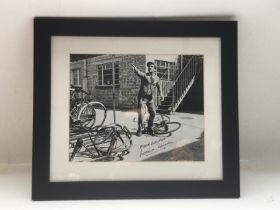 A framed and glazed signed photo of Norman Wisdom,