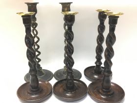 A collection of candlesticks including wood and br