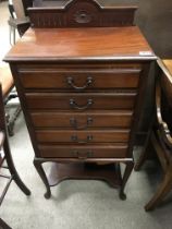 A 1920s Harrison & Gibson walnut music cabinet. 54