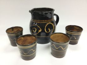 A Michael Cardew style jug and four conforming bea