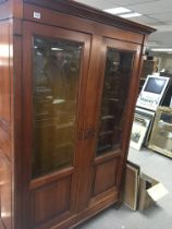 A French walnut cabinet with beveled glass doors.