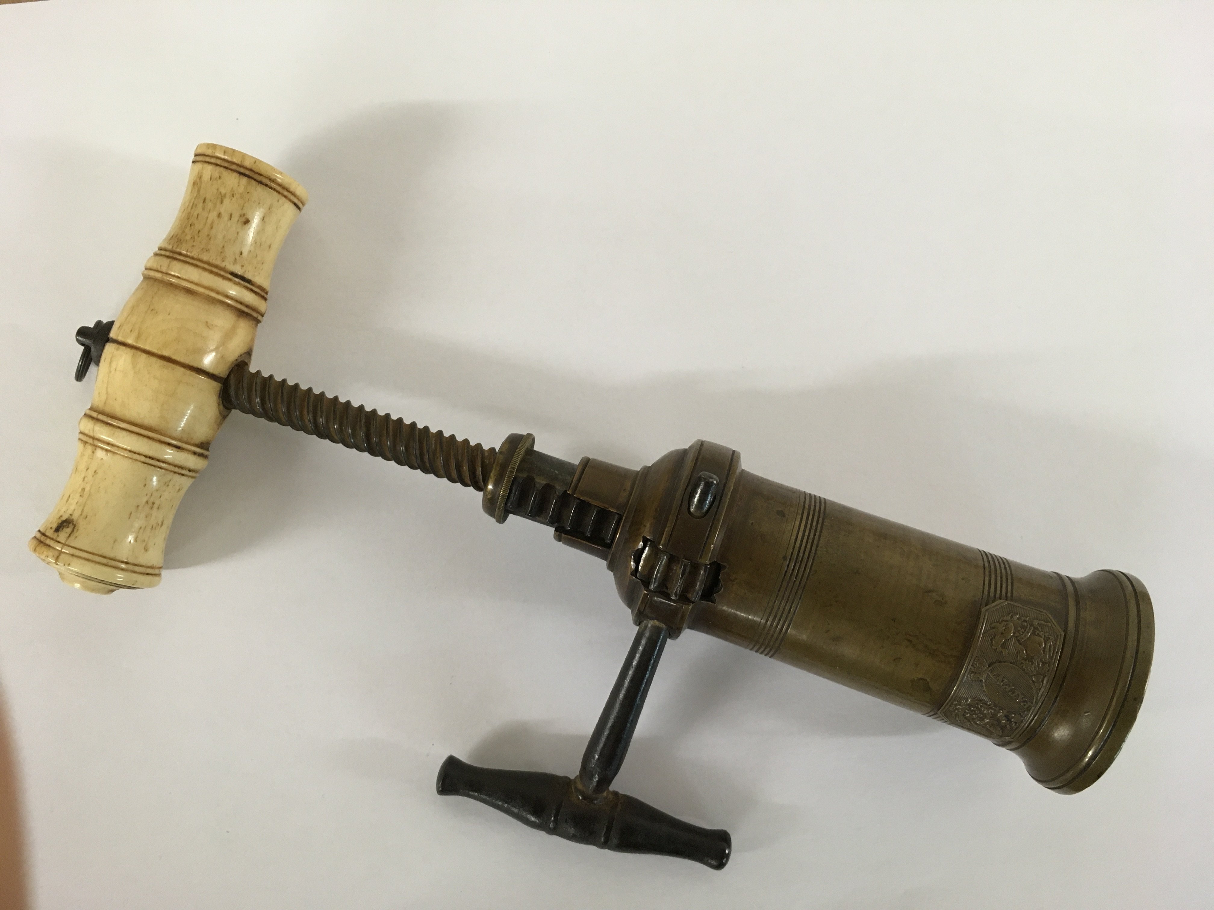 A brass barrel cork screw with bone handle
