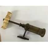 A brass barrel cork screw with bone handle