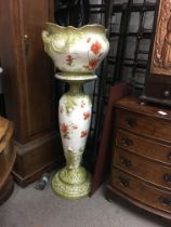 A Victorian jardiniere on stand decorated with pop