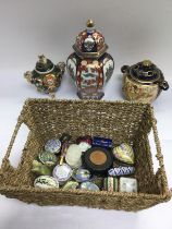 A basket of enamel pill boxes and Oriental ceramics. Shipping category D.