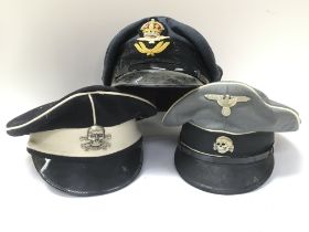 A collection of replica hats including Waffen SS o