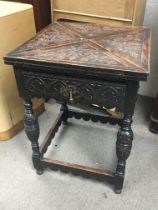 A Carved oak envelope card table with a quarter to