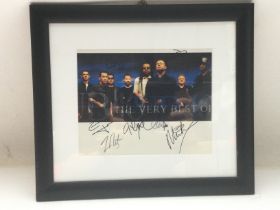 A framed and glazed photo of UB40 signed by the ba