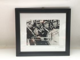 A framed and glazed signed photo of Norman Wisdom,