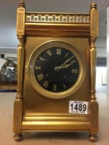 A brass cased mantle clock, striking on gong. The