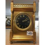 A brass cased mantle clock, striking on gong. The