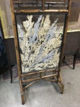 A bamboo fire screen the centre panel inset with f