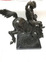 A Remington style bronze figure displayed on marbl