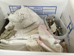 A box containing a quantity of vintage lace and lace bobbins.