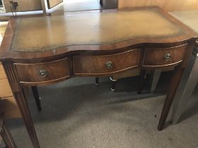 A three drawer mahogany writing desk with a leathe