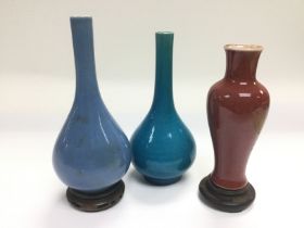 Three Oriental bud vases comprising a sang de boeu