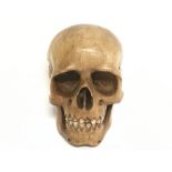 A Memento Mori carved fruit wood skull. 7cm tall, 4.5cm in diameter. Postage category A