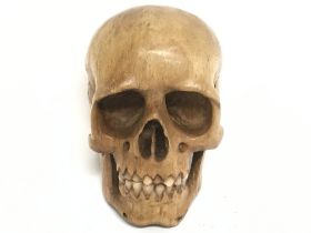 A Memento Mori carved fruit wood skull. 7cm tall, 4.5cm in diameter. Postage category A