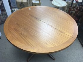 A modern teak dining table and four chairs. Table diameter approx 100cm.