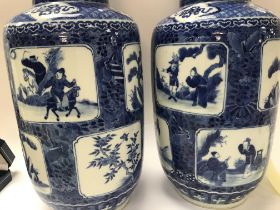 A pair of Chinese blue and white vases decorated with various panels depicting figures, birds
