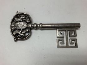 A silver Continental key corkscrew.