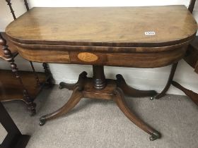 A Georgian mahogany card table the twin flap top above a turned column.